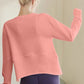 Back view of a woman in a sherbet-colored long sleeve sweatshirt, perfect for casual outings and lazy days.