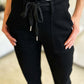 Woman wearing black high waist jeans with a drawstring, showcasing casual and comfortable style