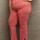 Woman wearing Bailey High Waist Side Slit Flare Jeans in pink, showcasing side slit detail and frayed hems from Risen Jeans.