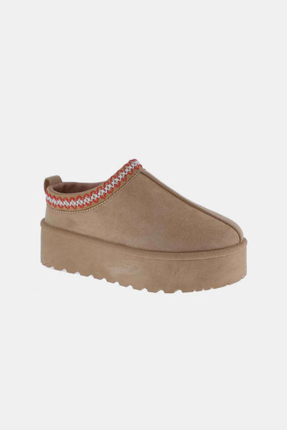 Tan platform slip-on boot with embroidered trim and chunky sole for a stylish and comfortable look.