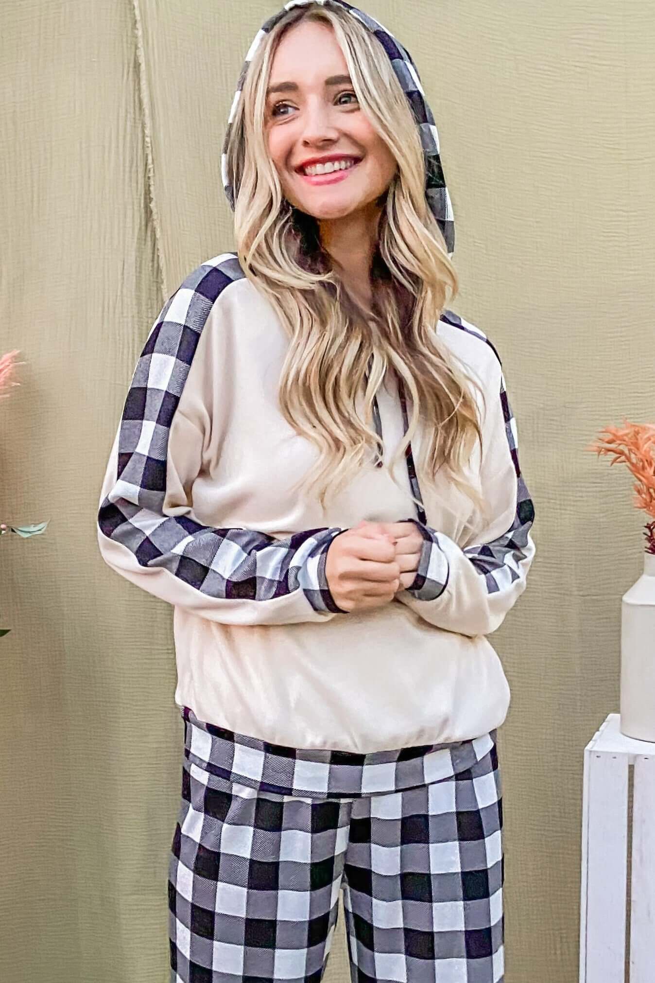 Smiling model in a cozy drawstring hooded top and plaid pants lounge set, perfect for stylish relaxation.