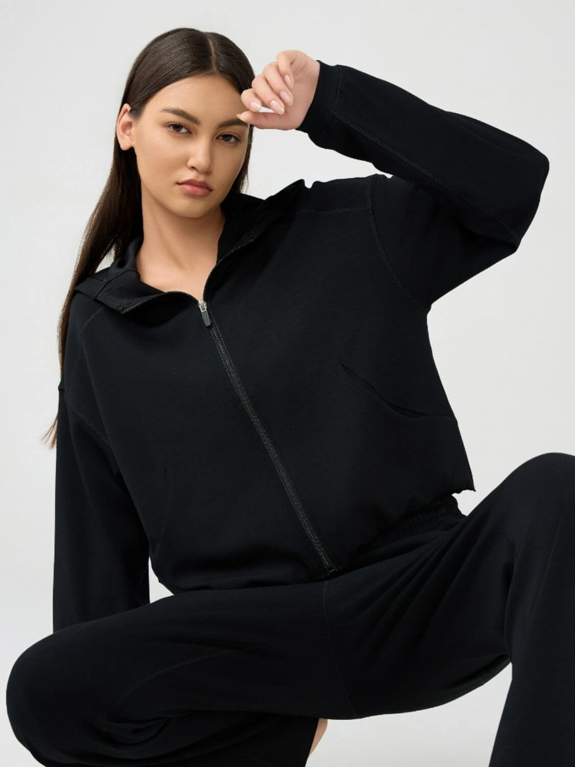 Model showcasing the Millennia Zip Up Dropped Shoulder Active Hooded jacket in black, perfect for stylish workouts and active lifestyles.