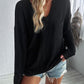 Woman wearing Double Take Pocketed Textured V-Neck Long Sleeve T-Shirt in black with distressed denim shorts.