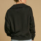 Model showcasing the back view of the stylish Umgee Johnny Collar Dropped Shoulder Sweatshirt in black, perfect for casual outfits.