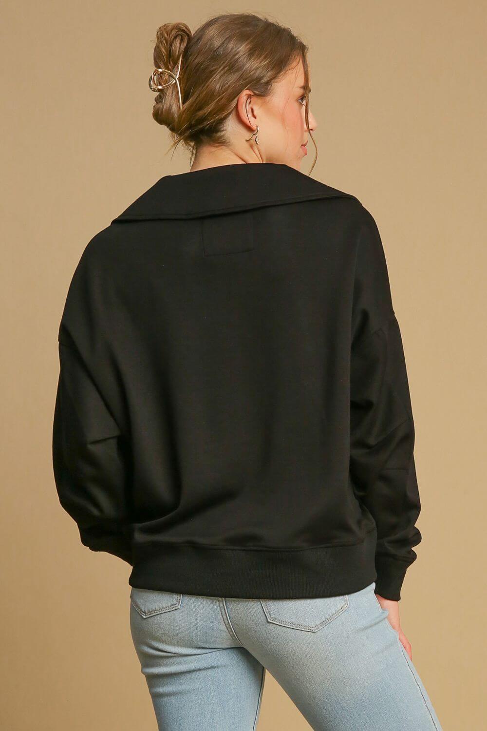 Model showcasing the back view of the stylish Umgee Johnny Collar Dropped Shoulder Sweatshirt in black, perfect for casual outfits.