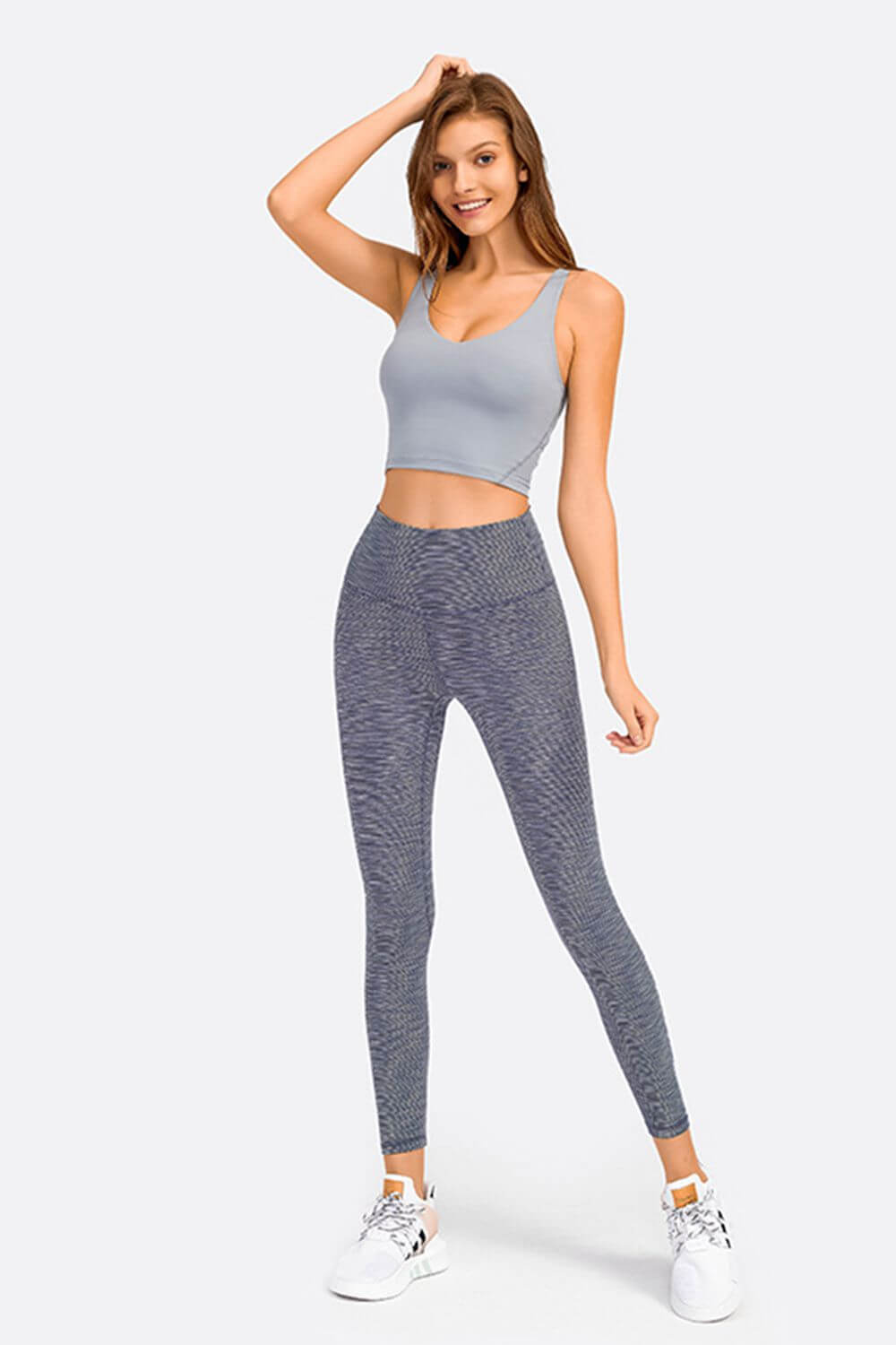 Model showcasing Millennia Deep V-Neck Crop Sports Bra paired with stylish leggings, perfect for gym workouts.