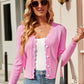 Woman wearing pink Bella Road Button Up Long Sleeve Cardigan, white top, sunglasses, and holding a white handbag.