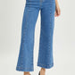 High-rise wide-leg Risen jeans for petites paired with black heels – perfect blend of retro flair and modern chic style.