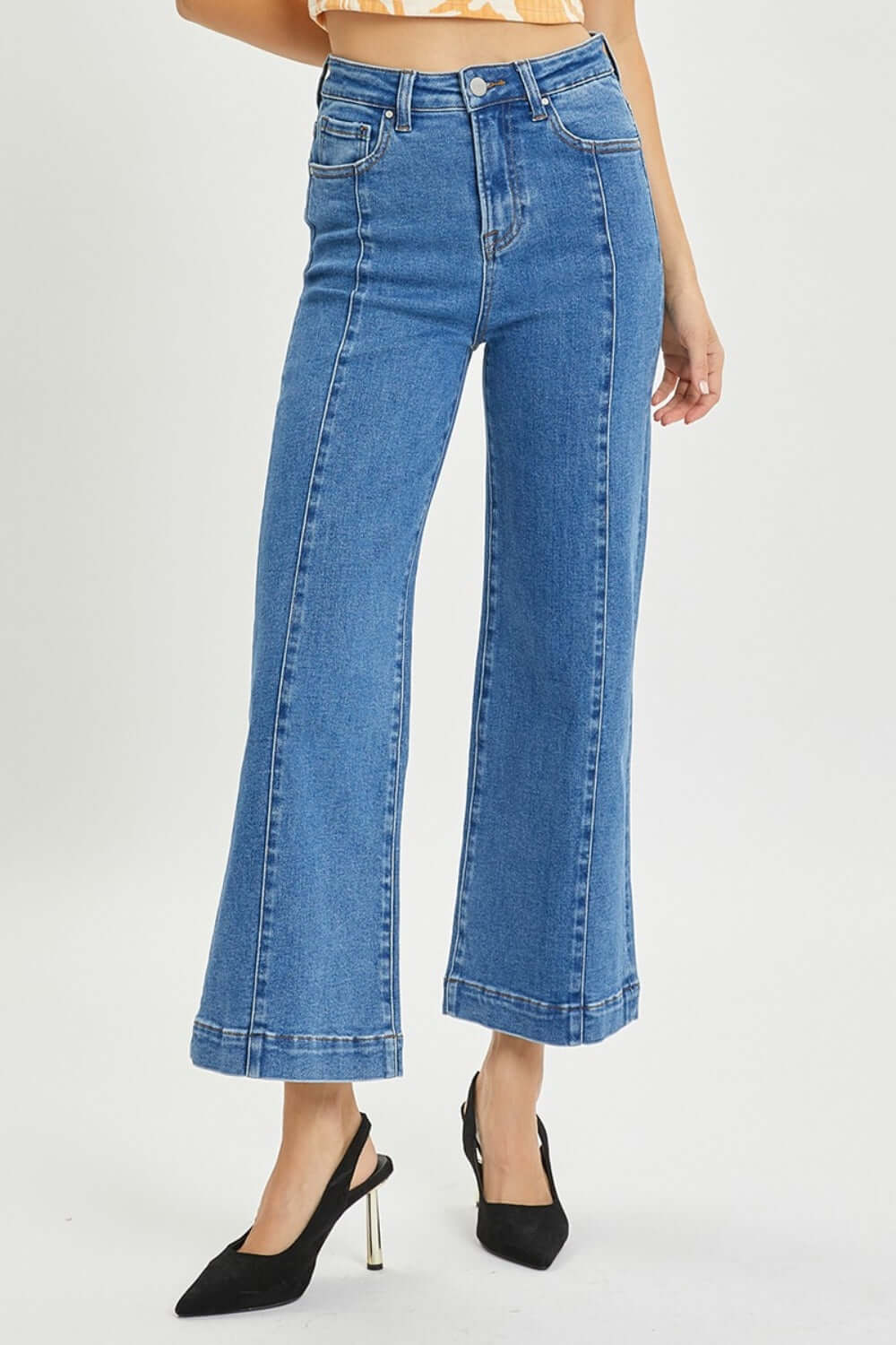 High-rise wide-leg Risen jeans for petites paired with black heels – perfect blend of retro flair and modern chic style.