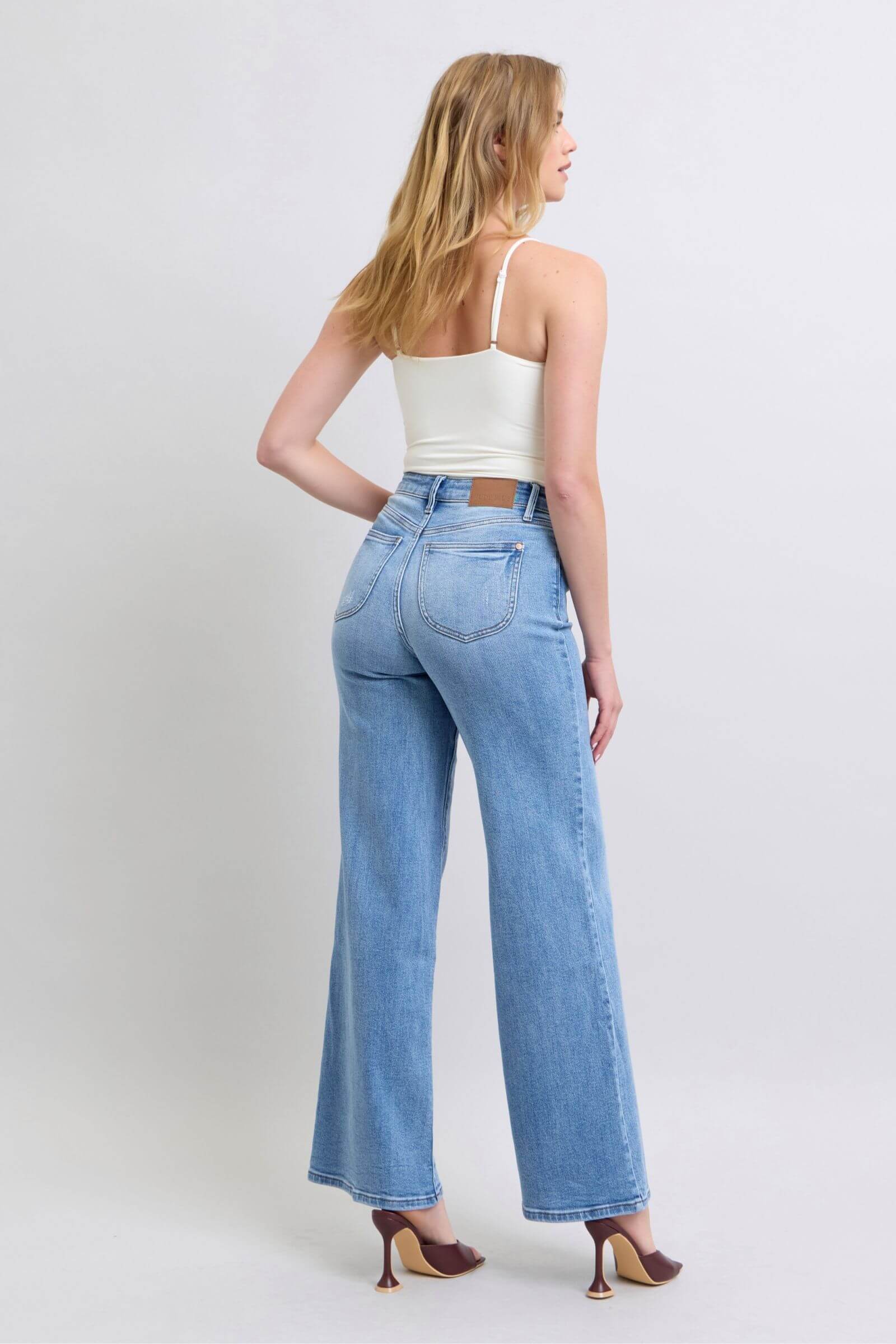 Judy Blue full-size wide leg jeans with pockets, styled with a fitted top and heels, showcasing a relaxed vintage look.