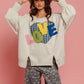 Model showcasing BiBi LOVE Heart Patch Slit French Terry Sweatshirt with a creative heart design against a pink backdrop.