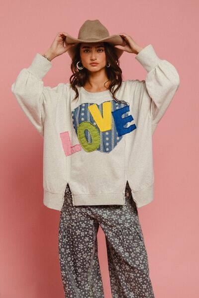 Model showcasing BiBi LOVE Heart Patch Slit French Terry Sweatshirt with a creative heart design against a pink backdrop.