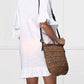 Model wearing Bella Road Swim cover up with ruffled sleeves, holding a stylish crochet bag.