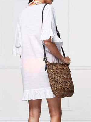 Model wearing Bella Road Swim cover up with ruffled sleeves, holding a stylish crochet bag.