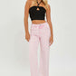 Stylish woman wearing high rise tummy control wide leg jeans in pink with a black crop top for a trendy look.