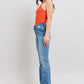 Model wearing Judy Blue high waist jeans with tummy control, featuring a vintage wash and side slit, styled with an orange top.