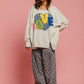 Model wearing BiBi LOVE Heart Patch Slit French Terry Sweatshirt with colorful LOVE patch and stylish boho pants.