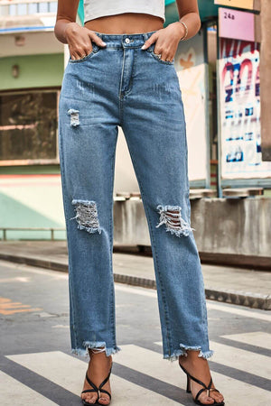 Woman wearing distressed buttoned loose fit jeans while posing on the street