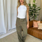 Woman wearing RFM Full Size High Rise Garment Dye Wide Leg Jeans in a stylish living room.