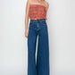 Woman wearing high rise palazzo jeans by Risen Jeans, showcasing a wide-legged silhouette and high-waisted fit for a fashion-forward look.