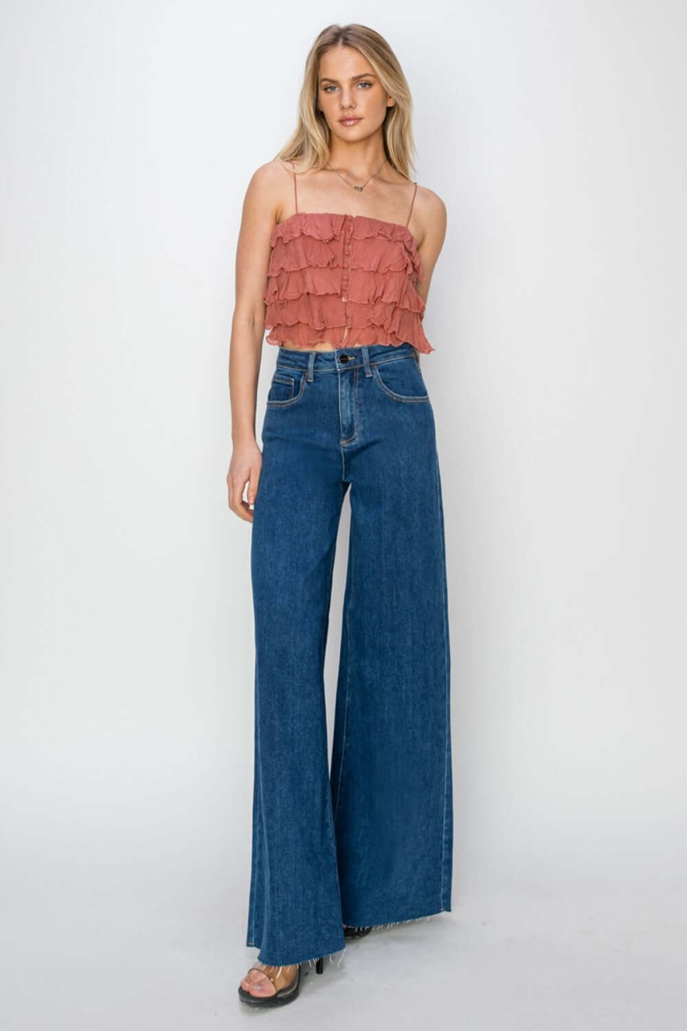 Woman wearing high rise palazzo jeans by Risen Jeans, showcasing a wide-legged silhouette and high-waisted fit for a fashion-forward look.