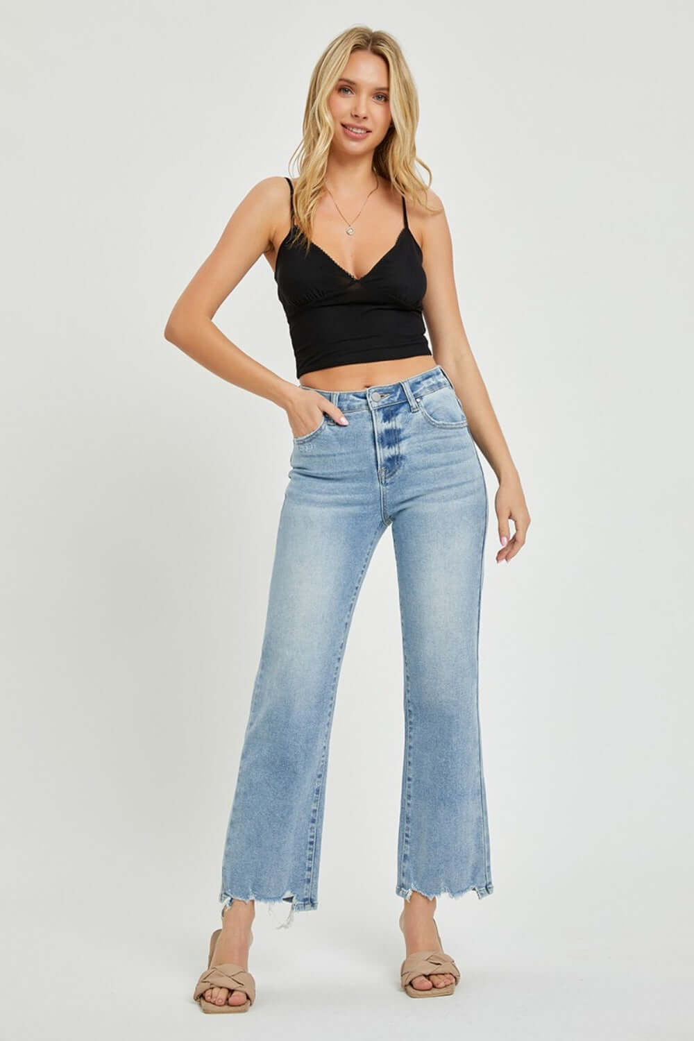 Woman wearing RISEN full size high-rise straight jeans with a black crop top, showcasing a chic and timeless silhouette.