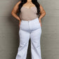 Woman wearing Raelene High Waist Wide Leg Jeans in White, showcasing a chic and modern look with a flattering high-rise waistline. Risen Jeans.