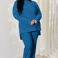 Curve model wearing blue ribbed high-low top and wide leg pants set, slightly stretchy two-piece outfit made of polyester and elastane.