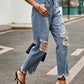 Woman wearing Bella Road Distressed Raw Hem Jeans with Pockets, styled with strappy heels and a black top, walking on a street.