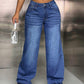 Woman wearing wide leg jeans with pockets, button closure, no stretch, made of 85% cotton and 15% polyester, holding a handbag.