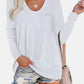 Woman wearing Bella Road Round Neck Long Sleeve T-Shirt with pocket, paired with denim shorts and beige bag