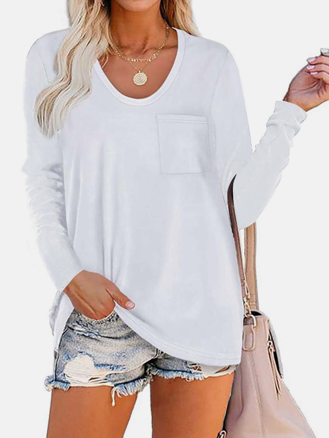 Woman wearing Bella Road Round Neck Long Sleeve T-Shirt with pocket, paired with denim shorts and beige bag