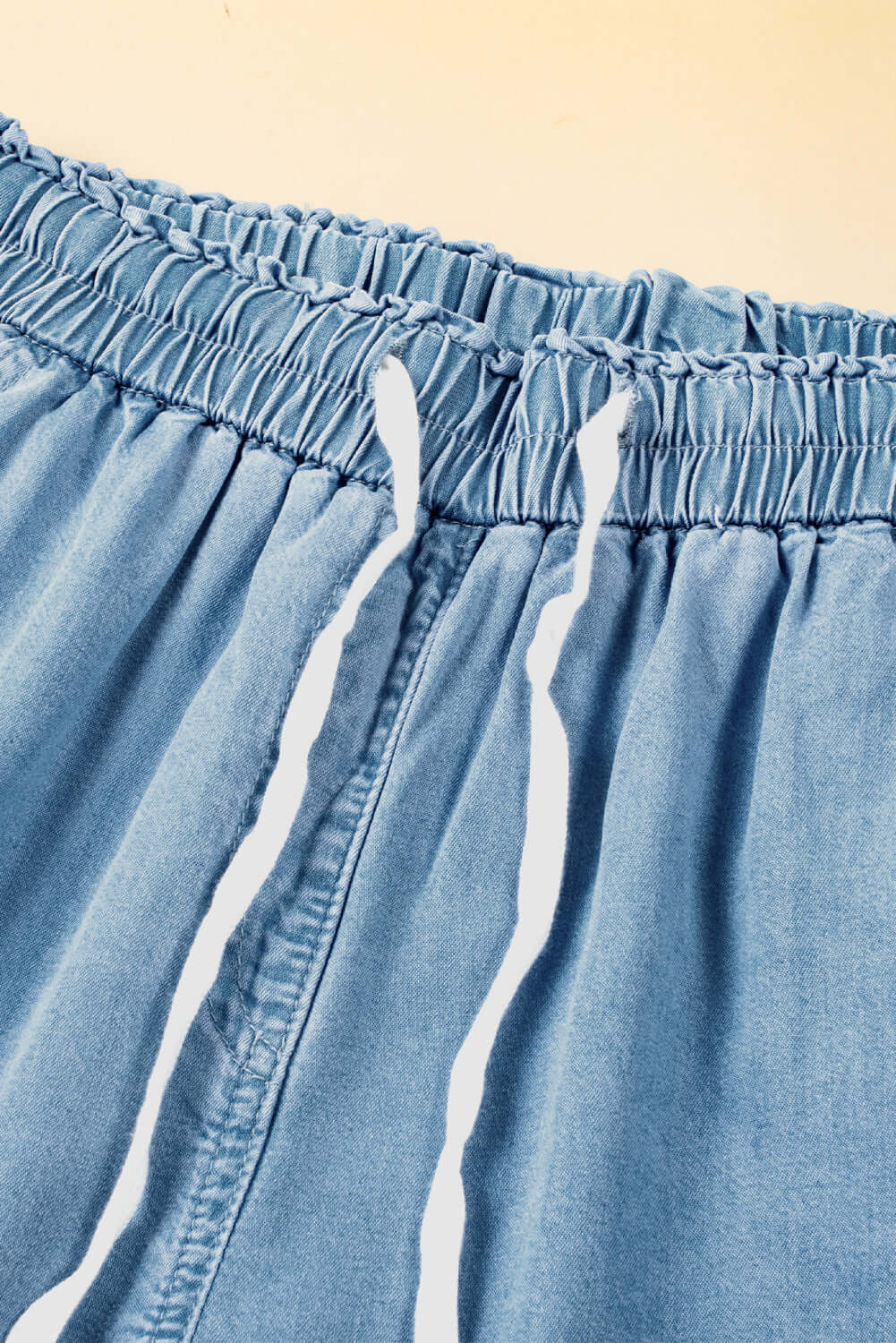 Close-up of the drawstring waistband on Bella Road light wash denim cargo wide leg jeans.