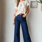 Woman wearing Mittoshop High Waist Wide Leg Jeans and white top, showcasing a chic and comfortable fashion ensemble.