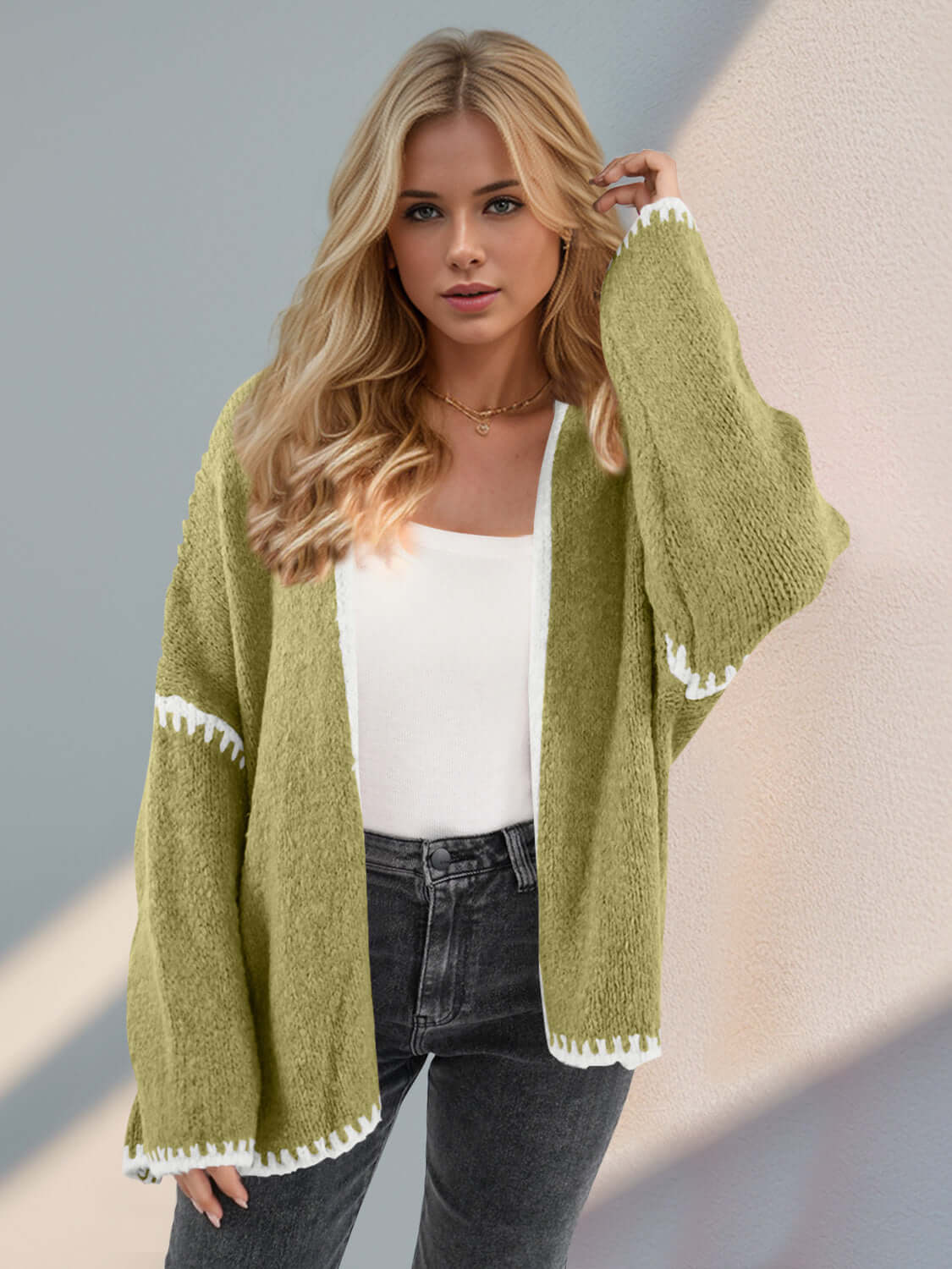 Trendy woman wearing green Double Take Contrast Cardigan with open front and dropped shoulders for a chic, relaxed look.