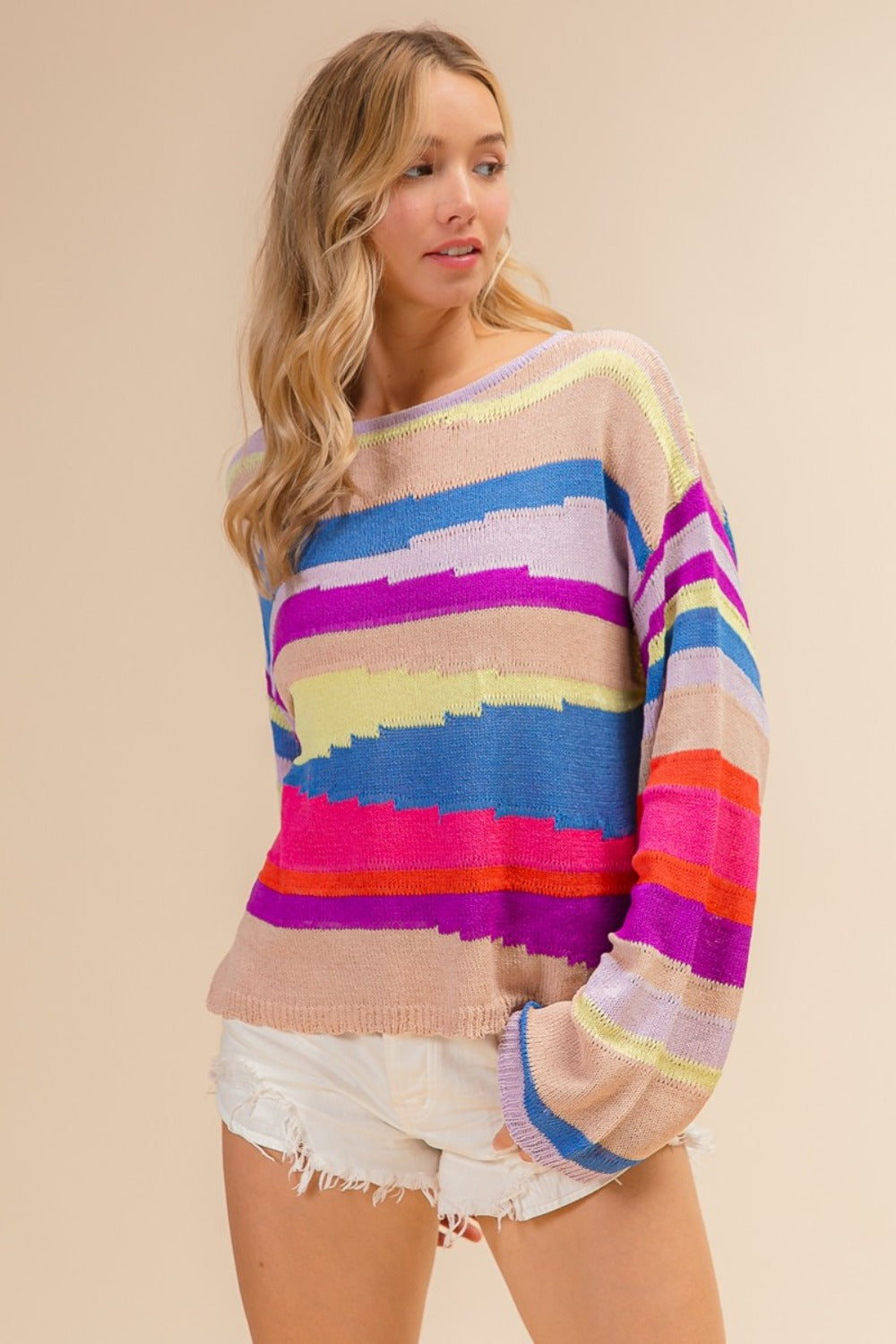 Woman wearing a BiBi Multi Color Geometric Stripe Sweater, showcasing vibrant modern stripes in a cozy knit fabric.