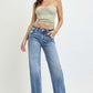 Stylish woman wearing RISEN high rise straight leg jeans with pockets, showcasing a flattering and fashionable look.