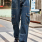 Woman wearing Baeful Long Straight Leg Jeans with pockets, walking outdoors in casual chic style.