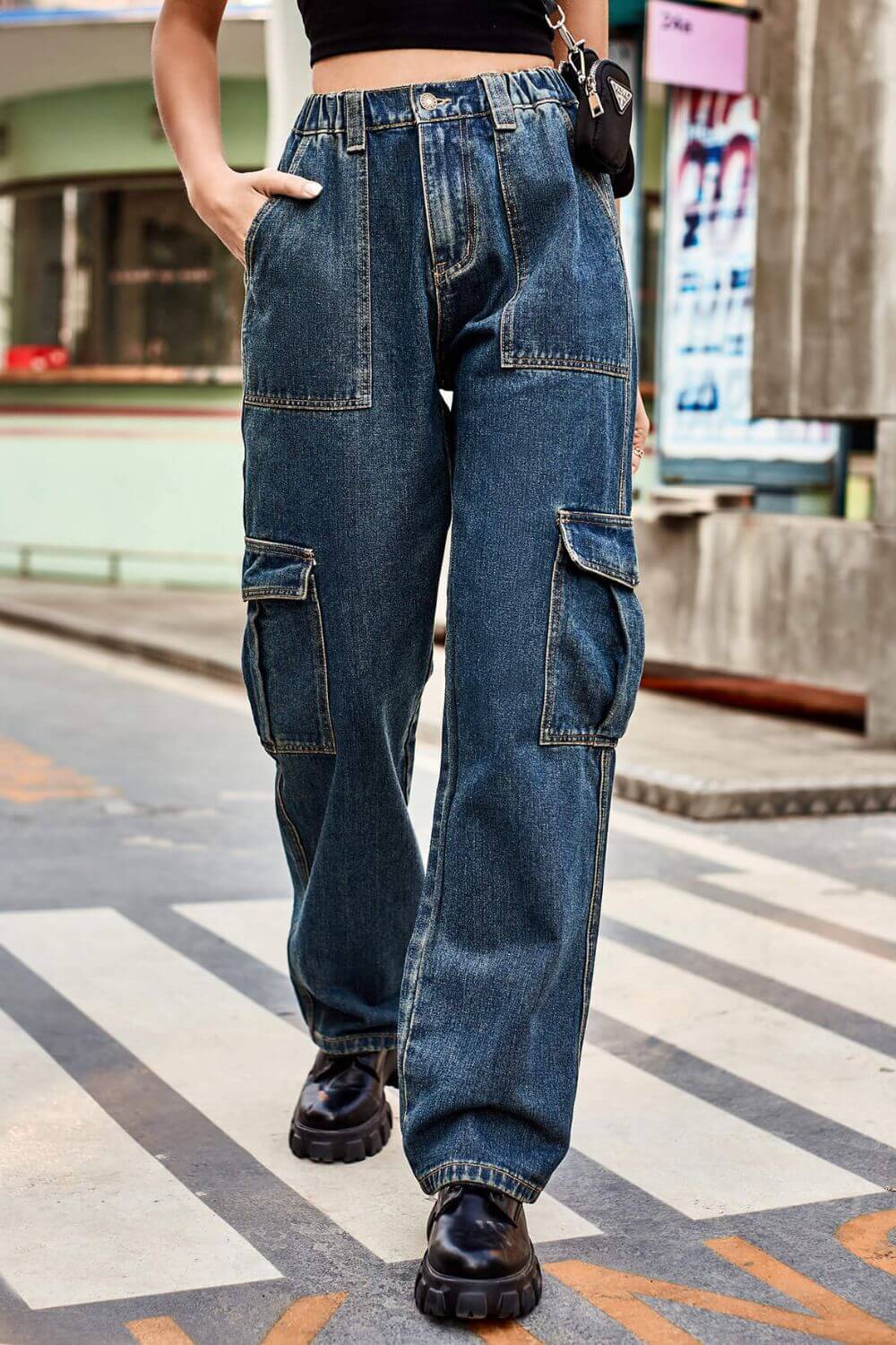 Woman wearing Baeful Long Straight Leg Jeans with pockets, walking outdoors in casual chic style.