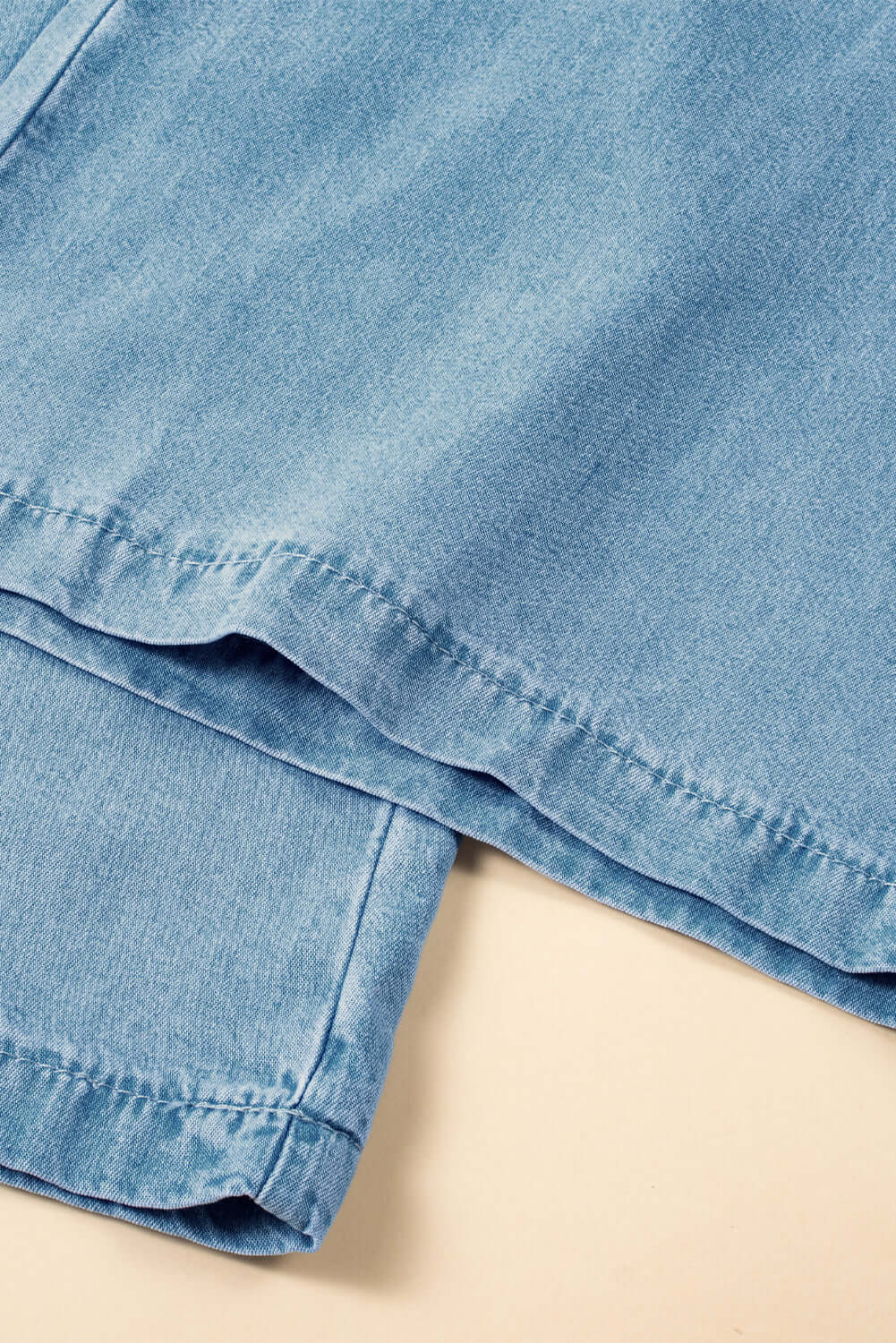 Close-up of Bella Road Denim wide leg jeans in light wash, showcasing drawstring waist and detailed stitching.