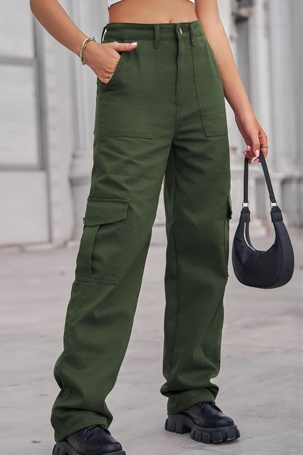 Woman wearing Baeful Long Straight Leg Jeans with Pockets in green, styled with a black purse and black chunky shoes