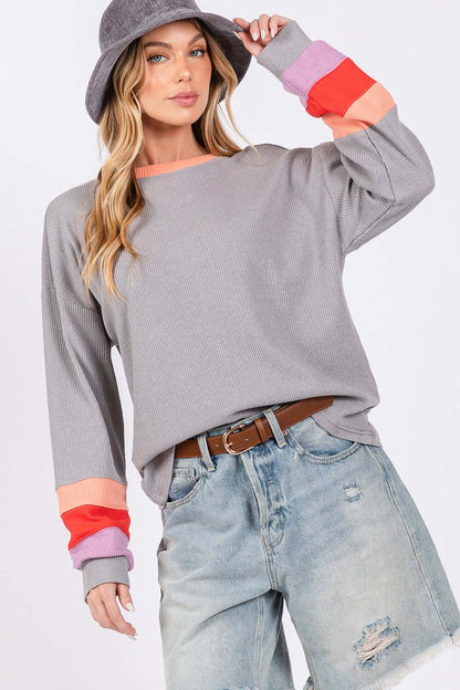 Woman wearing Color Block Waffle Knit T-Shirt with raglan sleeves and a contrast crew neckline, paired with ripped denim shorts and a hat.