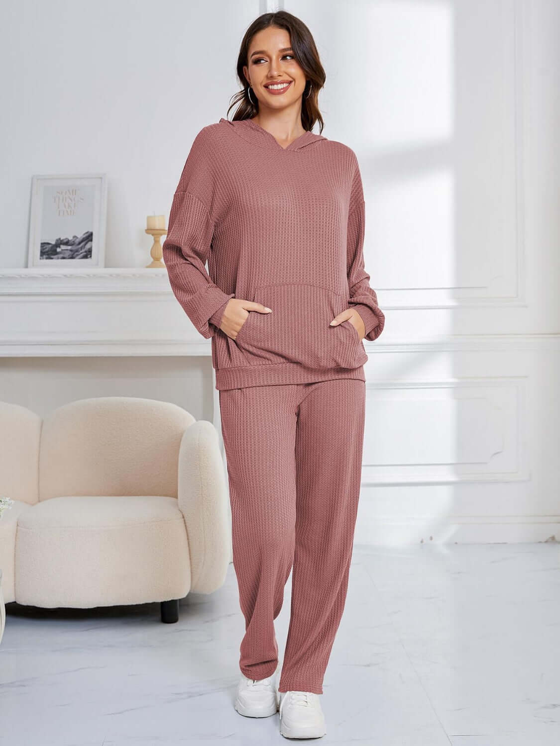 Woman in dusty pink Bella Road hoodie and pants set, cozy and stylish with pockets, perfect for lounging or errands.