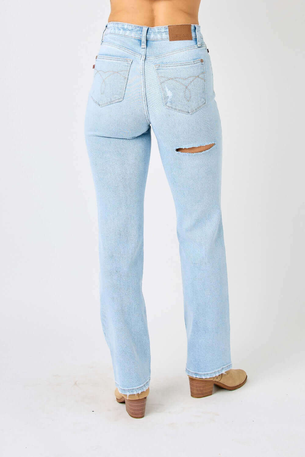 Back view of high waist distressed straight Judy Blue Jeans in light blue denim showing ripped detail and flattering fit.