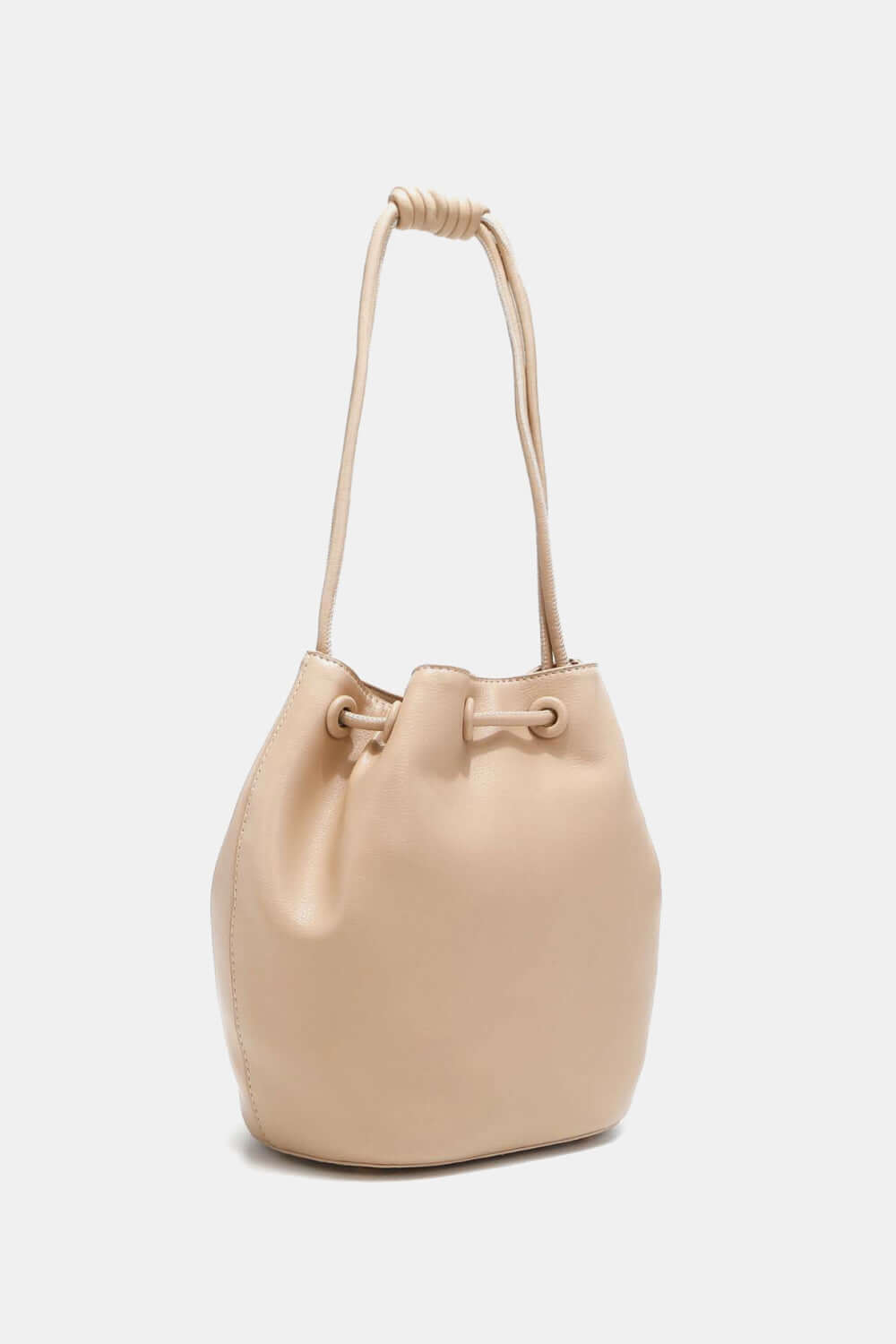 Nicole Lee USA Amy Studded Bucket Bag in beige vegan leather with drawstring closure and subtle stud detailing.