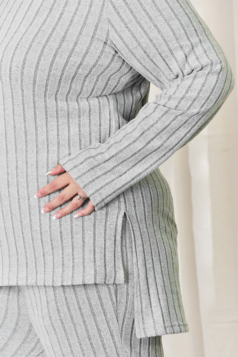 Ribbed high-low top and wide leg pants set in gray, close-up of model showing side slit and ribbed texture.