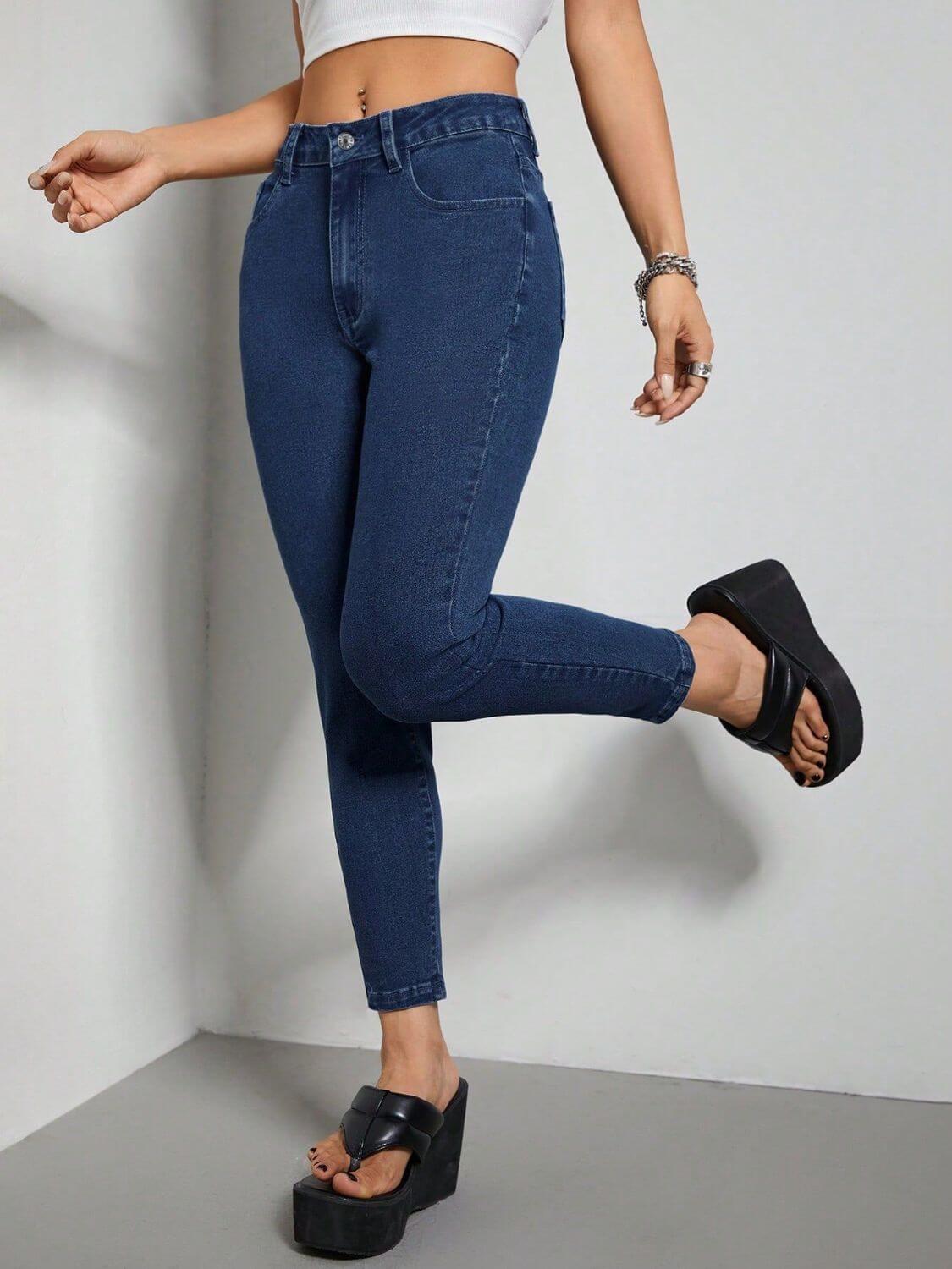 Woman wearing Bella Road Skinny Jeans with Pockets, dark blue, stylish and stretchy fit, paired with black platform sandals.