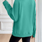 Woman wearing Ivy Lane Half Zip Raglan Sleeve Sweatshirt in teal color, showing back view.