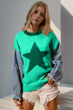 Woman wearing Double Take Full Size Star Pattern Raw Edge Long Sleeve Sweater in green with denim sleeves and shorts.