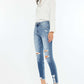 Woman wearing High Rise Frayed Ankle Skinny Jeans in medium wash paired with white top and blue heels.